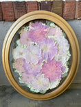 Load image into Gallery viewer, Decorative wall art with a circular arrangement of pink and purple flowers in a gold oval frame.