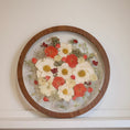 Load image into Gallery viewer, Round wooden frame with pressed flowers on a white surface