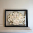 Load image into Gallery viewer, Framed artwork of white flowers on a beige wall
