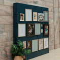 Load image into Gallery viewer, Navy blue wall with framed pictures against a brick wall background
