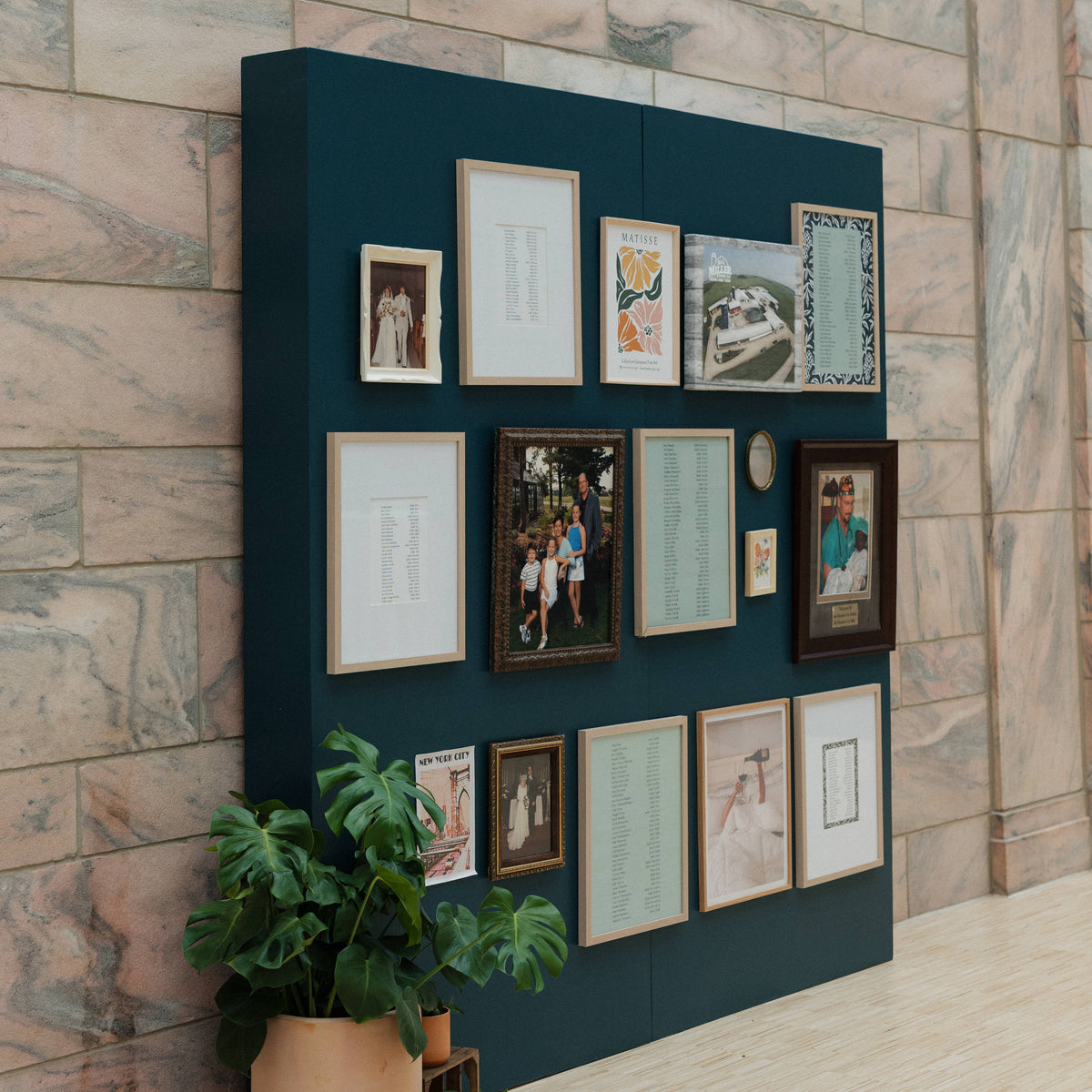 Navy blue wall with framed pictures against a brick wall background