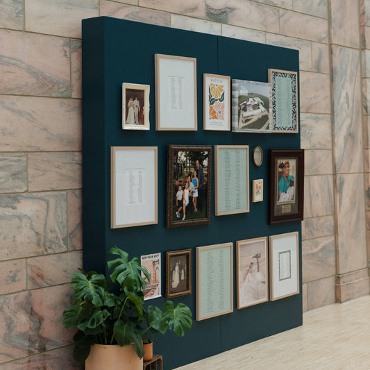Navy blue wall with framed pictures against a brick wall background