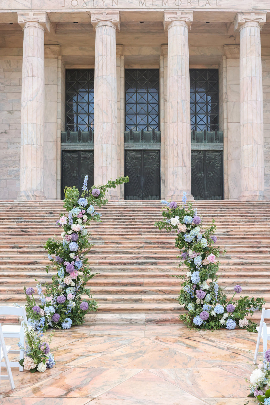 Floral arches on steps in front of a large building