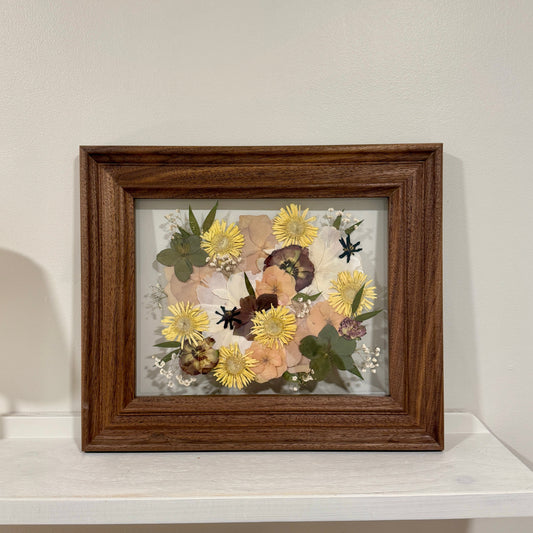 Framed floral artwork on a white surface with a light gray background