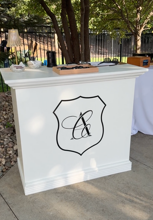 White bar with a decorative monogram logo outdoors