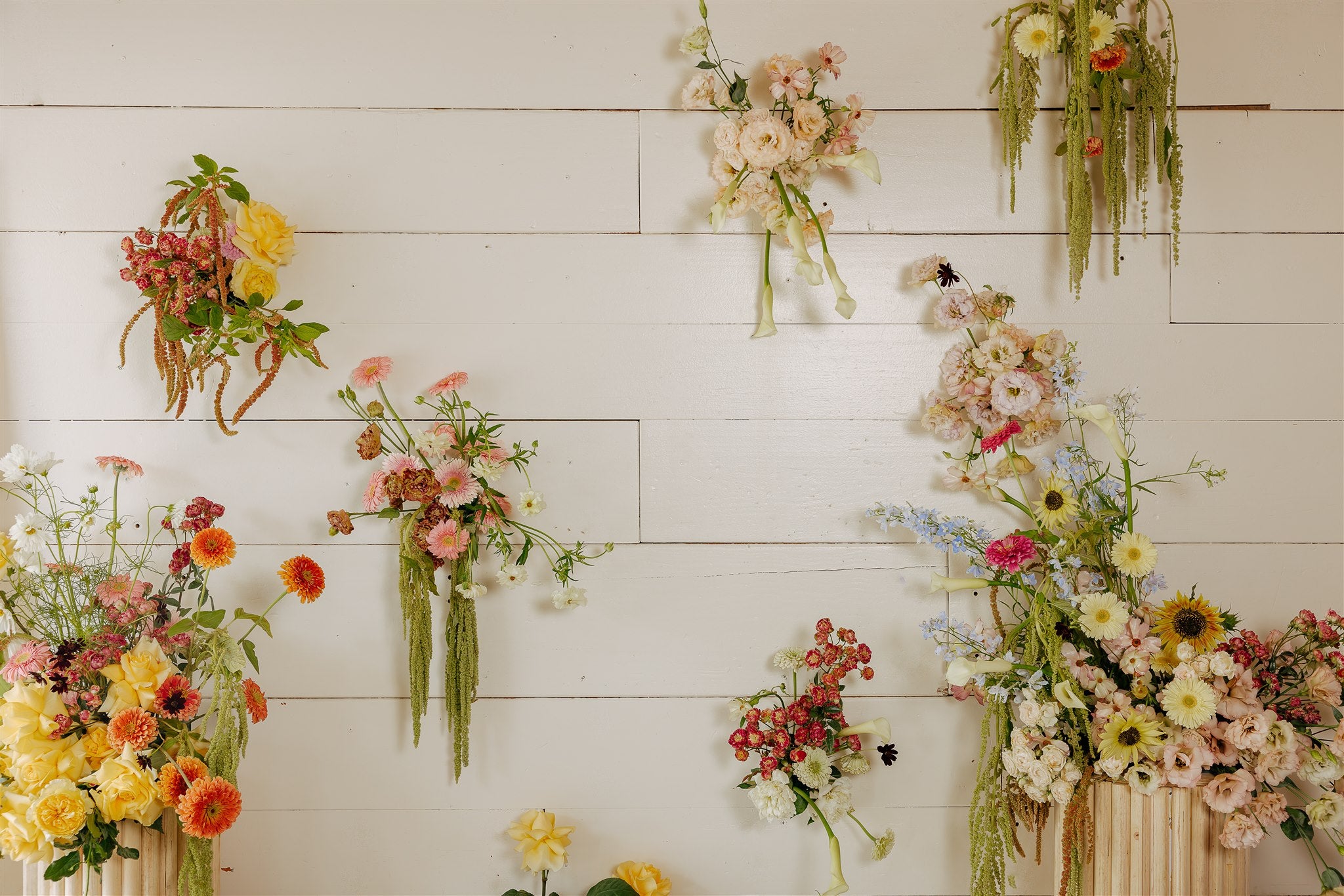 Various floral arrangements on a white wooden wall